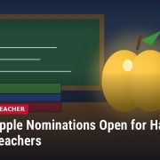 Illustration of a glowing golden apple on a wooden desk beside a stack of books and a chalkboard, with headline: Golden Apple Nominations Open for Hancock County Teachers